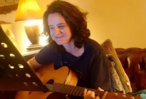 Shanti playing acoustic guitar